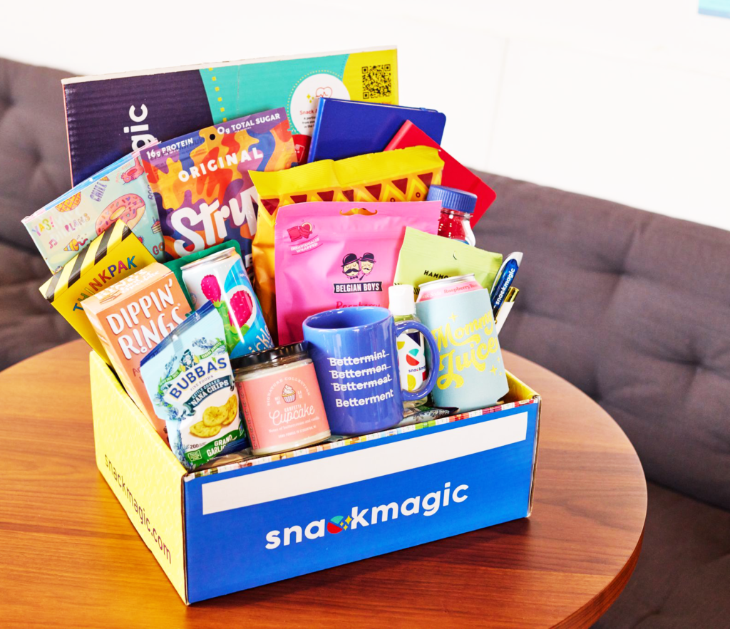 A SnackMagic box on a coffee table filled with a huge variety of snacks and gifts. 