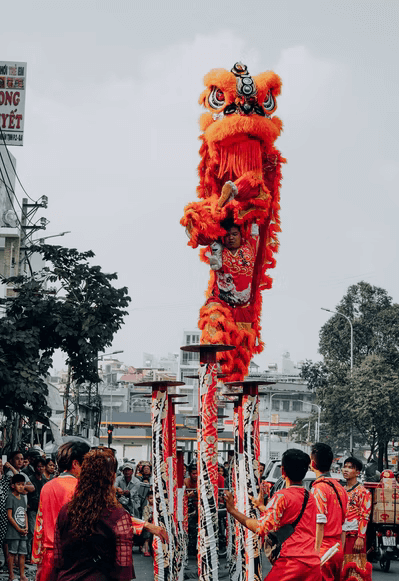 A long, colorful dragon is carried through the streets by dancers in a dragon dance.