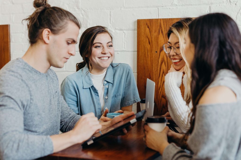 A group of employees shares morning coffee before a workday starts.